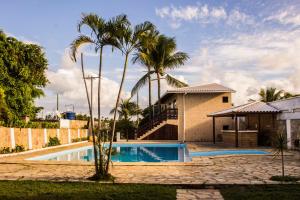 劳鲁-迪弗雷塔斯Vilas Florence的一座带游泳池和棕榈树的房子