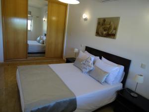 布尔高Casa Afonso Henriques的卧室配有一张带镜子的白色大床