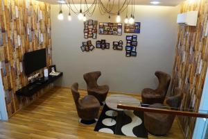 峇都丁宜三叶草精品别墅的客厅配有棕色椅子和电视