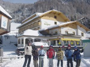 茵聂科里姆斯Hotel Berghof的一群站在建筑物前的雪中的人