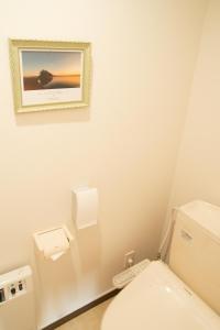 洞爷湖可可旅馆的一间带卫生间的浴室和墙上的照片