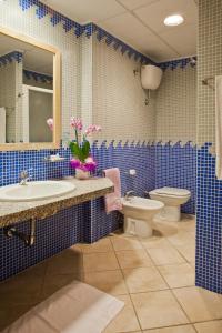托雷斯港利比索尼诗酒店的蓝色瓷砖浴室设有卫生间和水槽