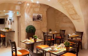 巴黎Hotel Saint Honore 85的一间带桌椅和石墙的餐厅