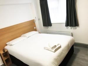 布伦特伍德Brentwood Guest House Hotel的卧室设有一张白色大床和一扇窗户。