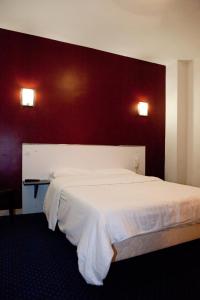巴黎皇家韦格勒姆酒店的卧室配有白色的床铺和红色的墙壁