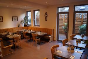 斯图加特豪斯特格潘森酒店的餐厅设有木桌、椅子和窗户。