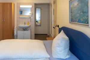 新伊森堡阿尔法公寓酒店 的一间卧室配有一张床和一个水槽及枕头