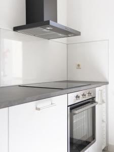 莱比锡City Park Apartments - #1-8 - Stilvolle Apartments zentrumsnah的厨房配有白色橱柜和炉灶烤箱。