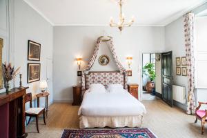 萨尔拉拉卡内达Appartements Les Suites sarladaises的卧室配有一张白色大床