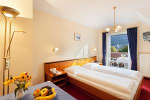 圣吉尔根Hotel Garni Wenglhof的一间卧室配有一张床和一张桌子及一碗水果