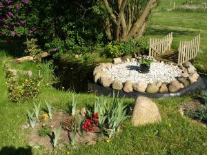 格赫伦-莱宾克兰里奇维斯度假屋的一个带长凳和一些花卉的花园和一个池塘