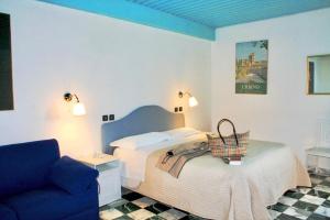 乌尔比诺Hotel Raffaello - Self Check-in Free的一间卧室配有一张床和一张蓝色的沙发