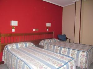 GibajaCasa Pardo的酒店客房设有三张床和红色的墙壁