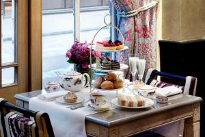 伦敦考文特花园酒店的餐桌,带食物,杯子和盘子