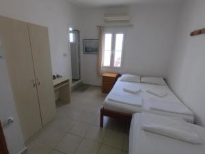 博德鲁姆玛哈巴旅馆的一间卧室设有两张床、一张桌子和一个窗口。
