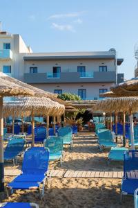 阿默达拉-伊拉克利翁Tropical Beach A的海滩上的蓝色椅子和遮阳伞