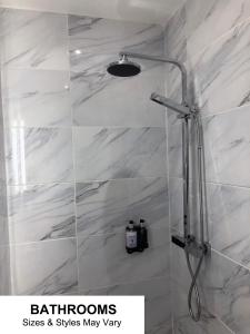 布莱克浦Seafront419 By Seafront Collection的浴室设有白色大理石瓷砖和淋浴。