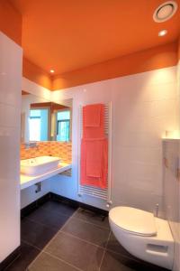 梅纳焦Sant’Andrea Penthouse的橙色浴室设有卫生间和水槽