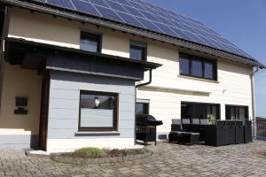 GefellFerienhaus "Am Backes"的屋顶上设有太阳能电池板的房子