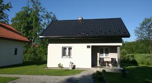 HoryniecKarolówka的一间黑色屋顶的白色小房子