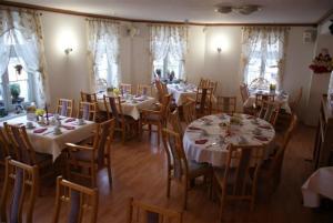 安格尔明德西托尔酒店的用餐室配有桌椅和白色的桌布