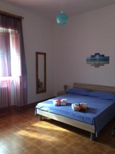 拉卡莱Casa "Salentus"的一间卧室配有一张带蓝色床单和镜子的床