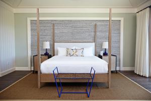 拿骚岛屿之家酒店的卧室配有一张白色大床和一把椅子