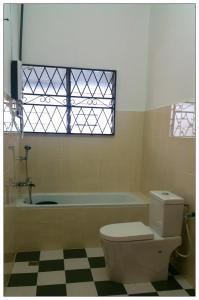 山打根GuestHouse Taman Megah, Lot 19的一间带卫生间和浴缸的浴室以及窗户。