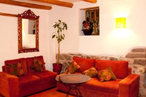 库斯科Amaru Colonial的客厅配有两张红色的沙发和一张桌子
