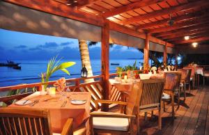 普拉兰大安塞区德梅尔别墅酒店的一间设有桌椅的海景餐厅
