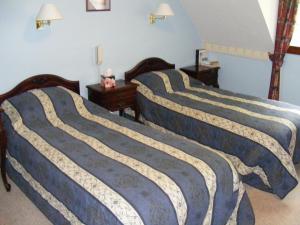 格伦芬南王子之家酒店的卧室设有三张床,拥有蓝色的墙壁