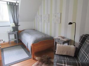 布兰肯海姆EIFEL Gästewohnung的一间卧室配有一张床、一张沙发和一把椅子