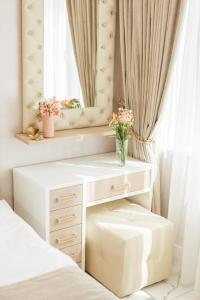 阿德勒Апартаменты на Тюльпанов 3的一间卧室配有书桌和鲜花窗户。