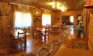 UznezyaHotel Complex Okolitsa的一间铺有木地板并配有木制桌椅的用餐室