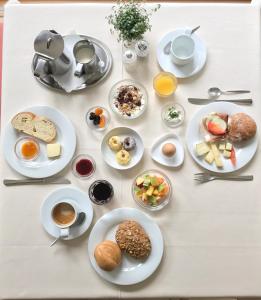 纳图尔诺Hotel Quellenhof的餐桌,盘子上放着食物和咖啡