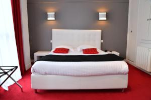 欧里亚克广场酒店的卧室配有一张带两个红色枕头的大型白色床