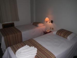 巴雷图斯Mabruk Barretos Apart Hotel的酒店客房设有两张床和电话