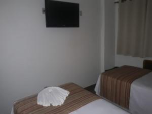 巴雷图斯Mabruk Barretos Apart Hotel的酒店客房设有两张床和一台平面电视。