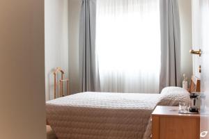 马里纳-迪-皮特拉桑塔2-bedroom apt, with balcony & aircondition - 50 m from the beach的一间卧室设有一张床和一个窗口