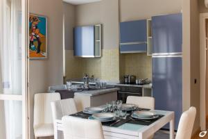 马里纳-迪-皮特拉桑塔2-bedroom apt, with balcony & aircondition - 50 m from the beach的厨房配有桌椅和冰箱。