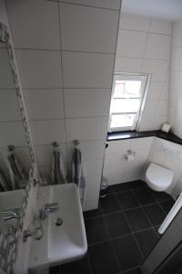 拜尔施泰因Winzerschenke的一间带水槽和卫生间的浴室以及窗户。