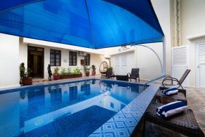 桑给巴尔Spice Palace Hotel的游泳池上方设有大型蓝伞