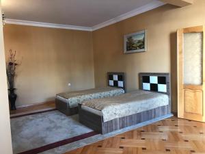 巴统Guest House kartvelishvili的铺有木地板的客房内的两张床
