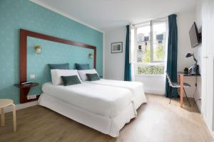 巴黎快乐文化普拉思酒店的卧室配有白色的床和蓝色的墙壁