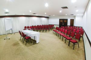 库里提巴阿拉丁酒店的一间会议室,配有红色椅子和白色桌子