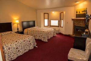 布鲁姆菲尔德Hilltop Inn Broomfield Denver的酒店客房设有两张床和壁炉