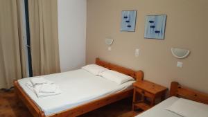 帕罗奇亚Aratos Hotel的一间小卧室,配有白色床单