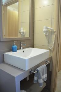 凯特利奥斯Aligis Studios的浴室设有白色水槽和镜子