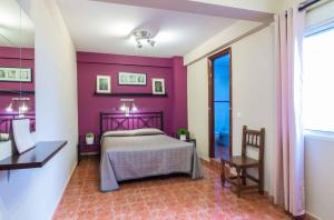 塞维利亚亨托夫特旅馆的一间卧室设有紫色墙壁和一张床