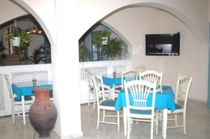 卡马利安德里亚斯酒店的一间配备有蓝色桌子和椅子的用餐室